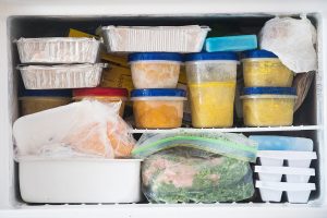 Inside view of a freezer with various food items neatly stored in containers and bags.